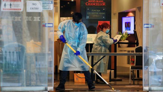 Hotel staff clean the entrance of Hotel Grand Chancellor on Lonsdale Street in Melbourne. Picture: Aaron Francis