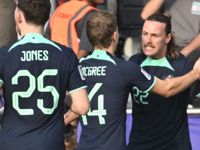 Australia's midfielder #22 Jackson Irvine celebrates with his teammates after scoring their first goal during the Qatar 2023 AFC Asian Cup Group B football match between Syria and Australia at the Jassim bin Hamad Stadium in Doha on January 18, 2024. (Photo by HECTOR RETAMAL / AFP)