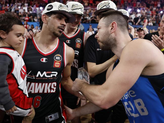 Matthew Dellavedova hands over his Finals MVP award to William Hickey of the Hawks. Picture: Getty Images