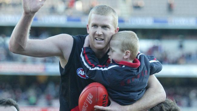 Dustin Fletcher holding a younger Mason after his 200th game.