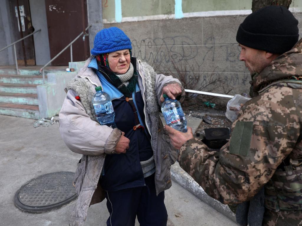 A woman is given food and water in Bakhmut, where 4500 civilians are still living as the city is besieged. Picture: Anatolii Stepanov/AFP