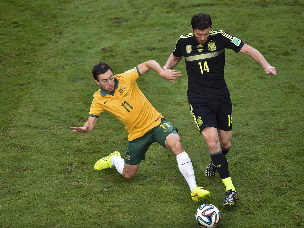 Tommy Oar (left) battles for the ball with Spain’s Xabi Alonso at the 2014 World Cup. Picture: AAP Image/Lukas Coch
