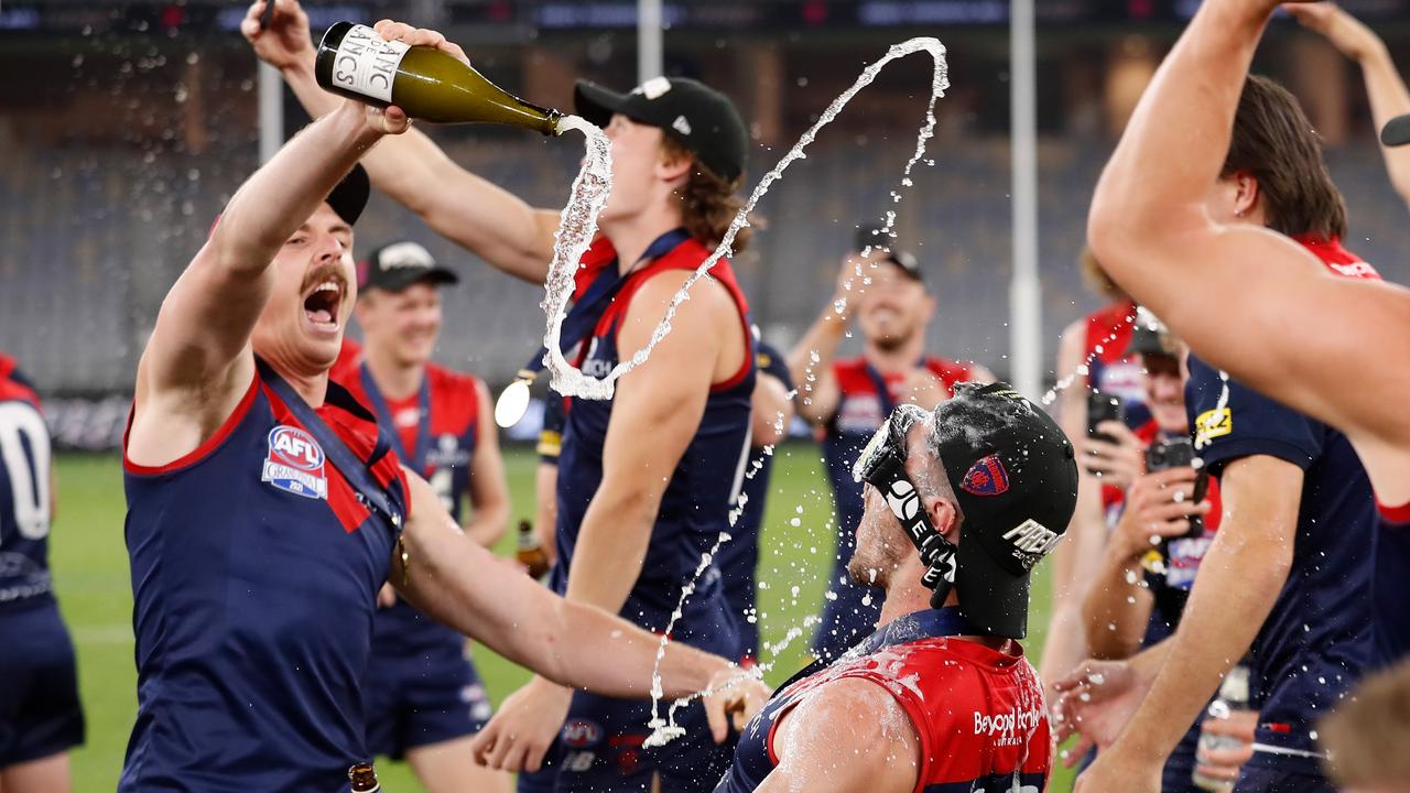 Jake Lever and Alex Neal-Bullen get loose as the Dees celebrate. Picture: AFL Photos/Getty Images