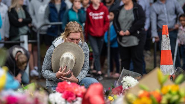 A grieving New Zealander pauses next to flowers outside Al Noor mosque in Christchurch yesterday. Picture: Getty Images