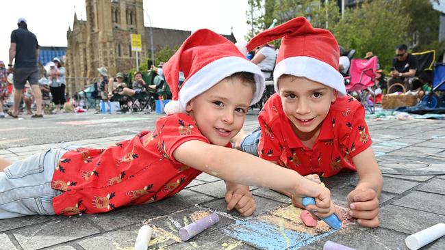 William, 5, and &amp; Edward, 7 drawing with chalk at the National Pharmacies Christmas Pageant. Picture: Keryn Stevens