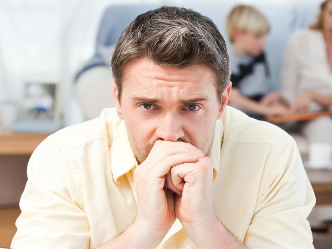 MORTGAGE STRESS .. Man calculating his bills while his family are on the sofa Picture: Thinkstock