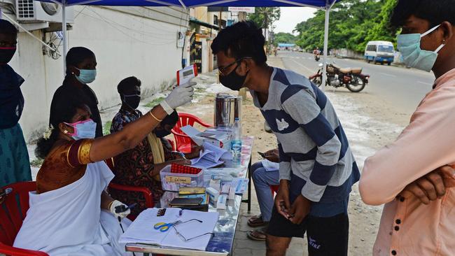 An Indian health worker checks the temperature of residents at a testing camp in Chennai. Picture: AFP