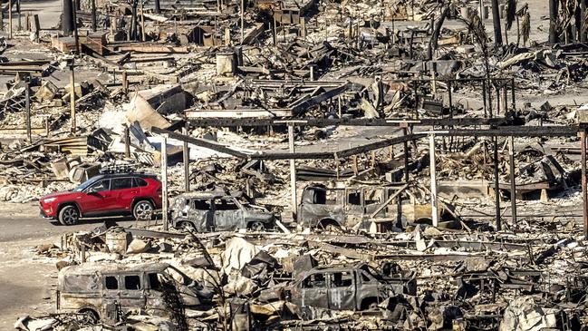 A car drives past homes and vehicles destroyed by the Palisades Fire at the Pacific Palisades Bowl Mobile Estates. Picture: AP Photo