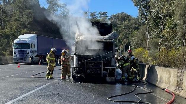 CFS firefighters at work on Thursday morning, extinguishing a truck fire at the tunnels on the South-Eastern Freeway. Picture: CFS