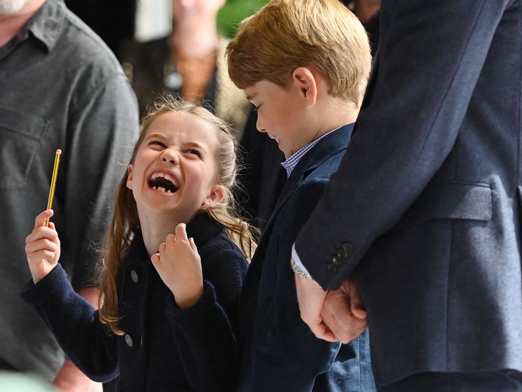 Princess Charlotte laughs as she conducts a band next to her brother Britain's Prince George during a visit to Cardiff Castle in Wales. Picture: AFP