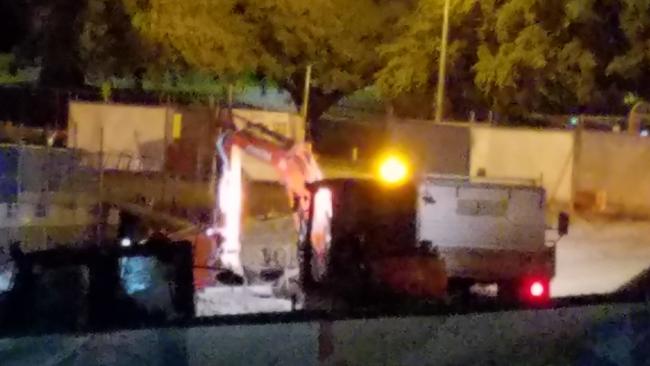 Machinery being used at night time at the site of a new inner-city school.