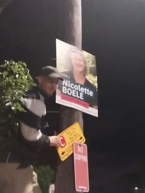 Two men were filmed putting up election posters for Nicolette Boele on a power pole. Picture: Supplied