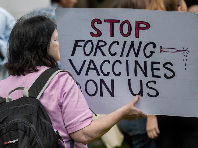 A protestor holding a placard is seen during the 'Wake Up Australia!' march against mandatory vaccinations at Hyde Park in Sydney, Saturday, May 30, 2020. (AAP Image/Bianca De Marchi) NO ARCHIVING