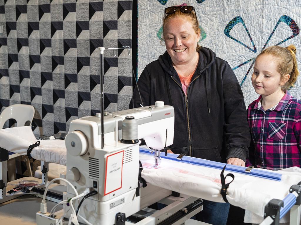 Lana Nash, with daughter Charlotte, uses a quilting machine at Craft Alive at the Goods Shed, Saturday, May 21, 2022. Picture: Kevin Farmer