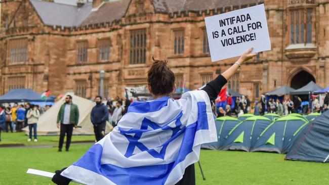 A member of the Australian Israeli community holds up a sign at the Palestinian Protest Campsite at the University of Sydney. Such university camps of students hostile to Israel and the Jewish people indicate there is something deeply unwell in our education system. Picture: Ayush Kumar/AFP