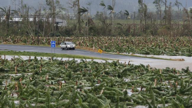 Locals still attempt drive along a flooded road from Innisfail to Tully on the morning after Cyclone Yasi hit the far North Coast of Queensland causing widespread damage and inundating land and roads.