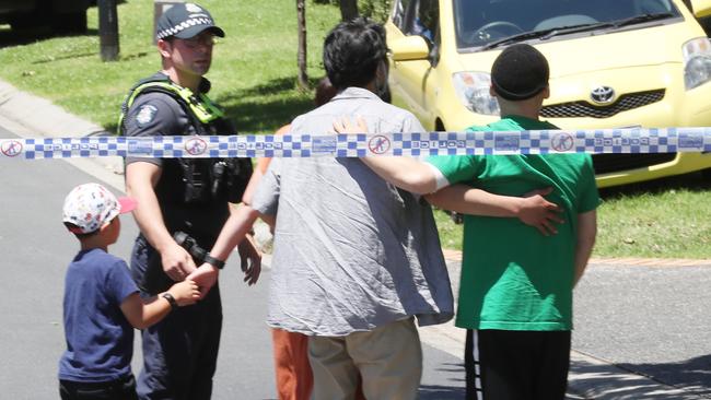 Police escort distressed people past the police tape and onto the crime scene. Picture: David Crosling