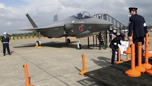 Japanese servicemen guard a mock-up of the F-35 during an air show. Pic: AP
