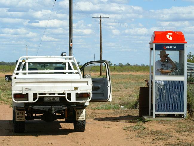 03/08/2005 WIRE: ** FILE ** Outback traveler John "Jim Buck" Howie uses a Telstra pay phone in the remote Post of Come-By-Chance 770 kilometers  (478 miles) west of Sydney, Australia, in this Nov 7, 2004 file photo. generic Australia's largest telecommunications company, Telstra Corp., has backed a plan to establish a multibillion dollar trust fund to ensure ongoing services to rural areas following the planned sell-off of the company next year.(AP Photo/Rob Griffith)