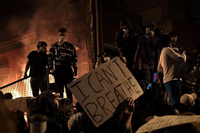 The 3rd precinct police building burns as protesters watch in St Paul, Minnesota. Picture: AFP