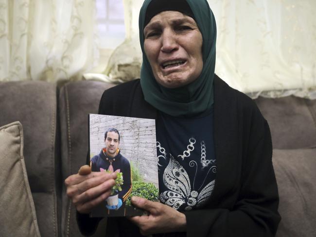 Rana, mother of Iyad Halak, 32, holds his photo at their home in East Jerusalem's Wadi Joz, Saturday, May 30, 2020. Israeli police shot dead a Palestinian near Jerusalem's Old City who they had suspected was carrying a weapon but turned out to be unarmed. A relative said Halak was mentally disabled and was heading to a nearby school for people with special needs. (AP Photo/Mahmoud Illean)