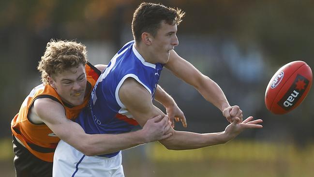 Lachlan Reidy of the Ranges gets the hand ball away before the tackle of Declan Willmore.