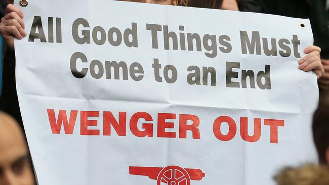 Arsenal fans hold up anti - Arsene Wenger signs.