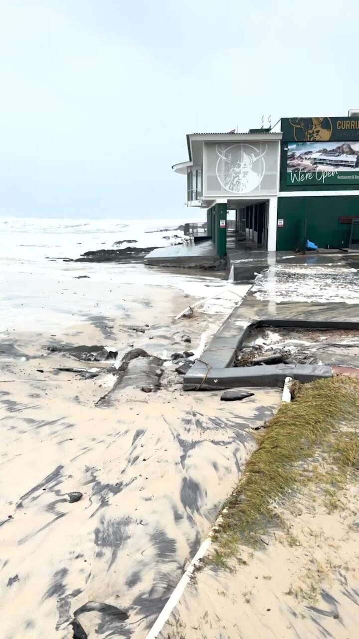 Water surging through Currumbin Surf Club carpark as high tide approaches