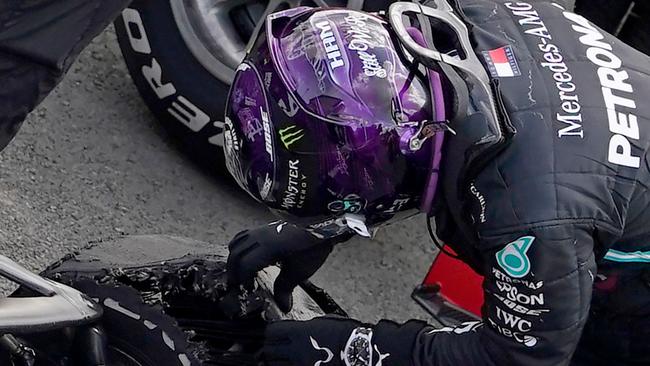 Lewis Hamilton inspects his punctured tyre