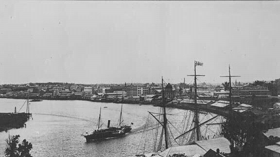 A steamer passes Kangaroo Point leaving the pre-story bridge port of Brisbane at the end of the 19th century.