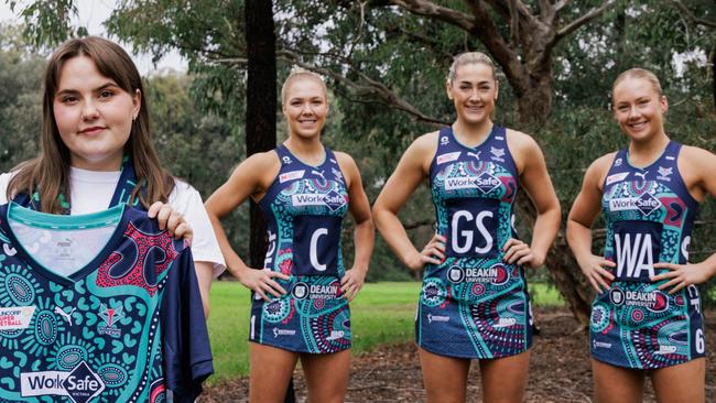 Proud Kamilaroi woman and artist Teagan Malcolm with the dress displaying the imagery she created for the Melbourne Vixens' First Nations round with (from left) Kate Moloney, Sophie Garbin and Hannah Mundy in the dress. Photo: Wiradjuri photographer Joshua Scott.