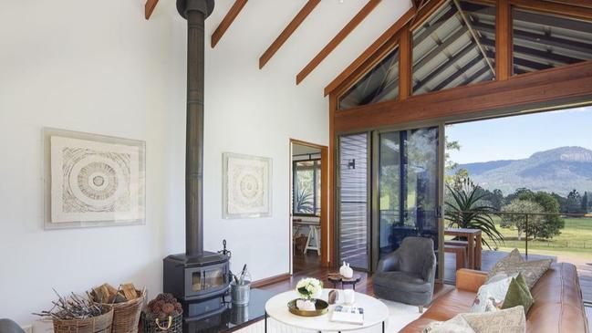 An open-plan living space has a pitched beamed ceiling.