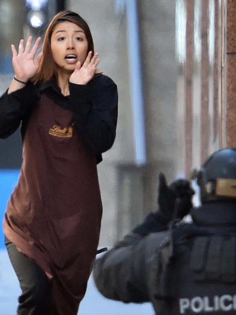 One of the hostages runs towards police during the Lindt cafe siege. Picture: Saeed Khan (AFP)