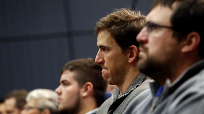 New York Giants quarterback Eli Manning, center, reacts while listening to former head coach Tom Coughlin speak during a news conference, Tuesday, Jan. 5, 2016, in East Rutherford, N.J. (AP Photo/Julio Cortez)