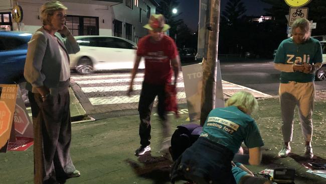 Zali Steggall (far left) attends to a supporter who collapsed. Picture: Julie Cross.