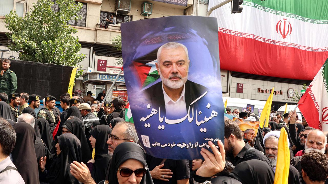 Iranians hold portraits of late Hamas leader Ismail Haniyeh during his funeral procession, in Tehran, on August 1, 2024, ahead of his burial in Qatar. (Photo by AFP)