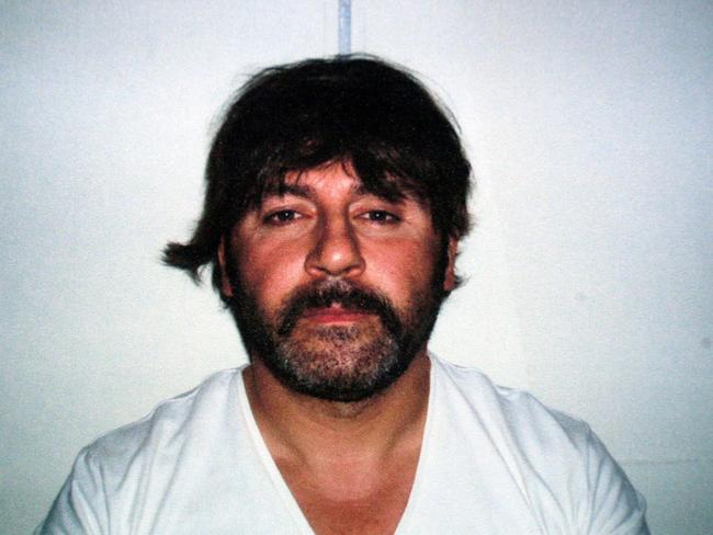 A police photo of Tony Mokbel wearing a wig after being arrested in Athens in 2007.