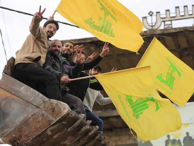 Men sitting in a bulldozer's bucket wave Hezbollah's flags as they celebrate a ceasefire between Israel and Hezbollah in Zefta, southern Lebanon. Picture: AP