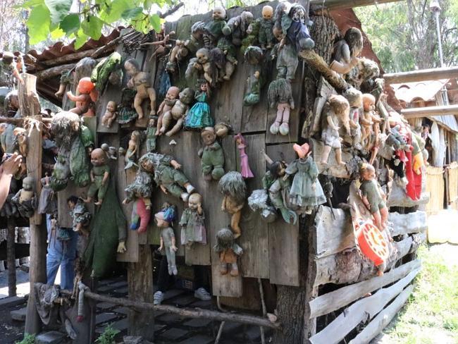 A collection of dolls hanging from a wooden hut on Isla De Las Munecas, Xochimico, Mexico. Picture: Wikimedia Commons/Emy Pheebs