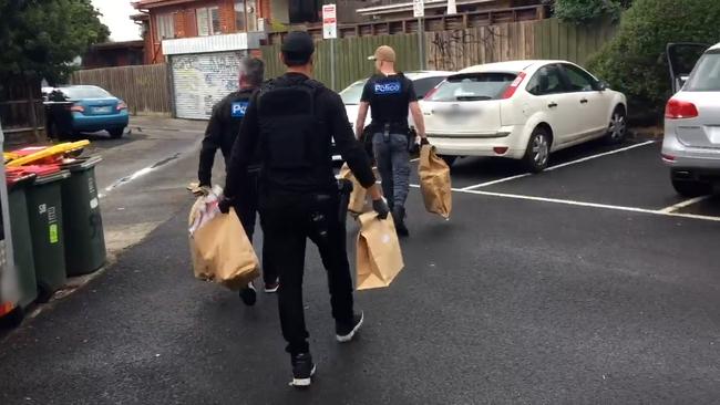 Police carry evidence from the scene of a drug raid in Ormond