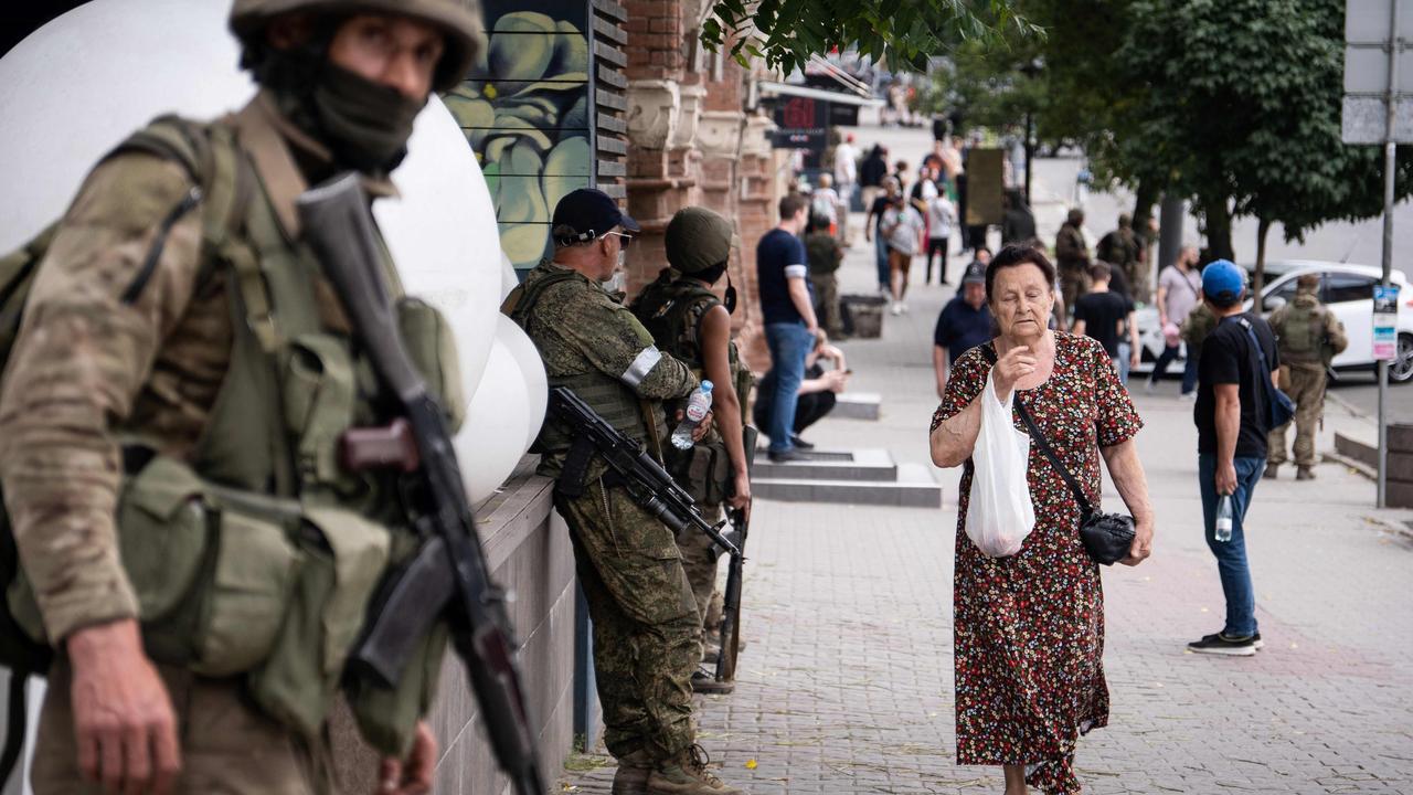 A local resident walks past members of Wagner group in Rostov-on-Don on Saturday. Picture: AFP