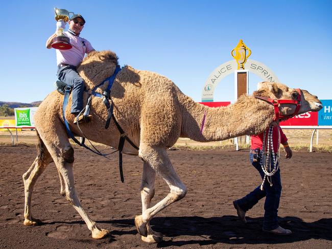 Jimmy Cassidy carries the Melbourne Cup at The Camel Cup in Alice Springs. Picture: Mark Stewart