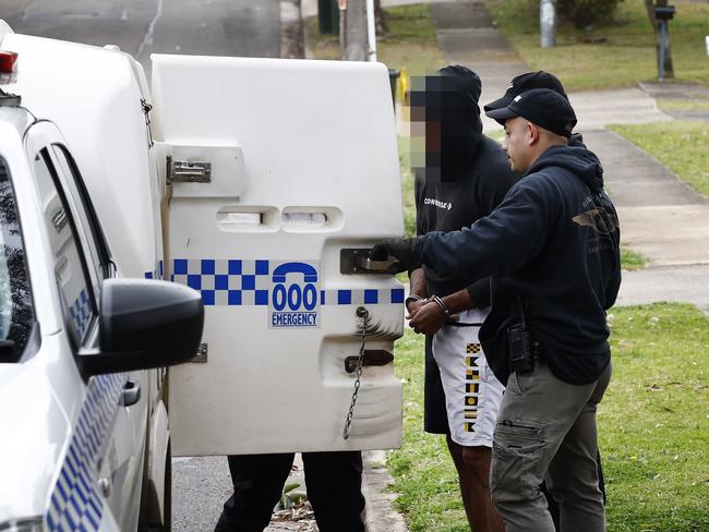 A man accused of breaching his AVO is removed from a property in the Blacktown area. Picture: Richard Dobson