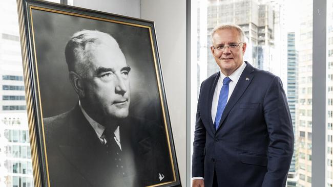 Scott Morrison poses for a photo standing next to a photograph of Sir Robert Menzies