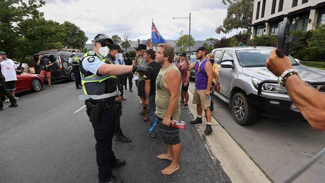 A police officer speak to a man during the Canberra protest. Picture: NCA/Gary Ramage