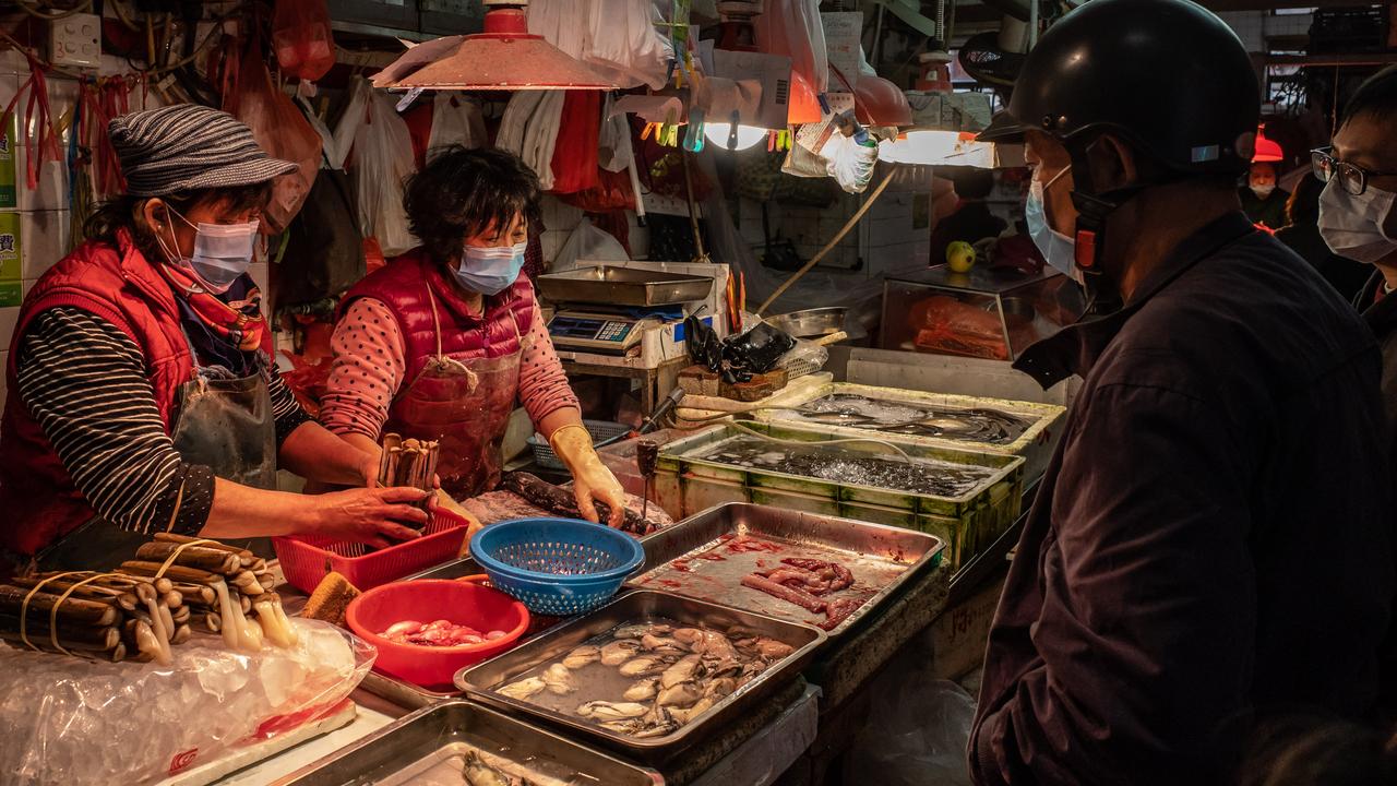 Residents in face masks buy seafood at a wet market in January in Macau, China. Picture: Anthony Kwan/Getty Images