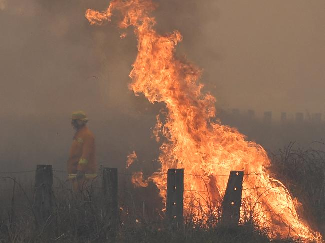 ***ALTERNATIVE CROP***  A spot fire is seen on the Bunyip side of the Princes Highway in Victoria, Sunday, March 3, 2019. The fires in Bunyip State Park started after lightning strikes on Friday afternoon, with 300 emergency workers deployed to fight the blazes. (AAP Image/James Ross) NO ARCHIVING