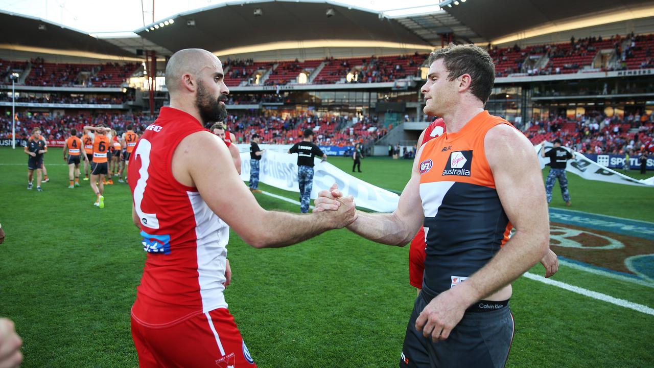 Brothers Rhyce and Heath Shaw shake hands during an AFL match. Photo: Phil Hillyard