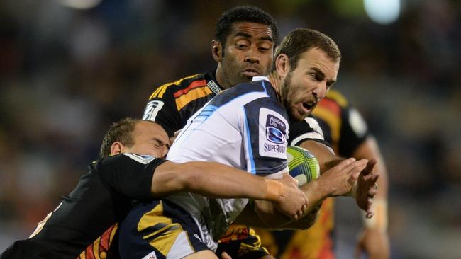 ACT Brumbies' Nic White (centre) is tackled by Waikato Chiefs' Andrew Horrell (left) during the Round 11 Super Rugby match between the Brumbies and the Chiefs at GIO Stadium in Canberra, Friday, April 25, 2014. (AAP Image/Lukas Coch) NO ARCHIVING, EDITORIAL USE ONLY