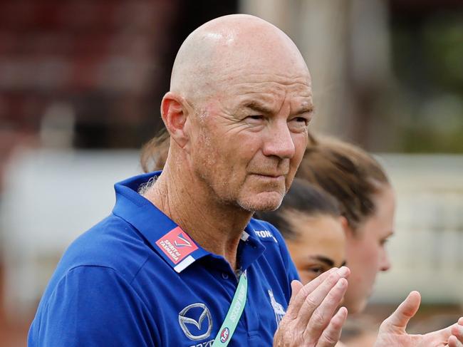 MELBOURNE, AUSTRALIA - NOVEMBER 23: Darren Crocker, Senior Coach of the Kangaroos lines up with his players for the prematch ceremony and national anthem during the 2024 AFLW First Preliminary Final match between the North Melbourne Tasmanian Kangaroos and the Port Adelaide Power at IKON Park on November 23, 2024 in Melbourne, Australia. (Photo by Dylan Burns/AFL Photos via Getty Images)